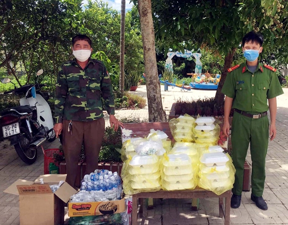 Ông Phan Huy (bên trái) bàn giao 50 suất cơm cùng nước uống hỗ trợ đồng bào trong khu cách ly.